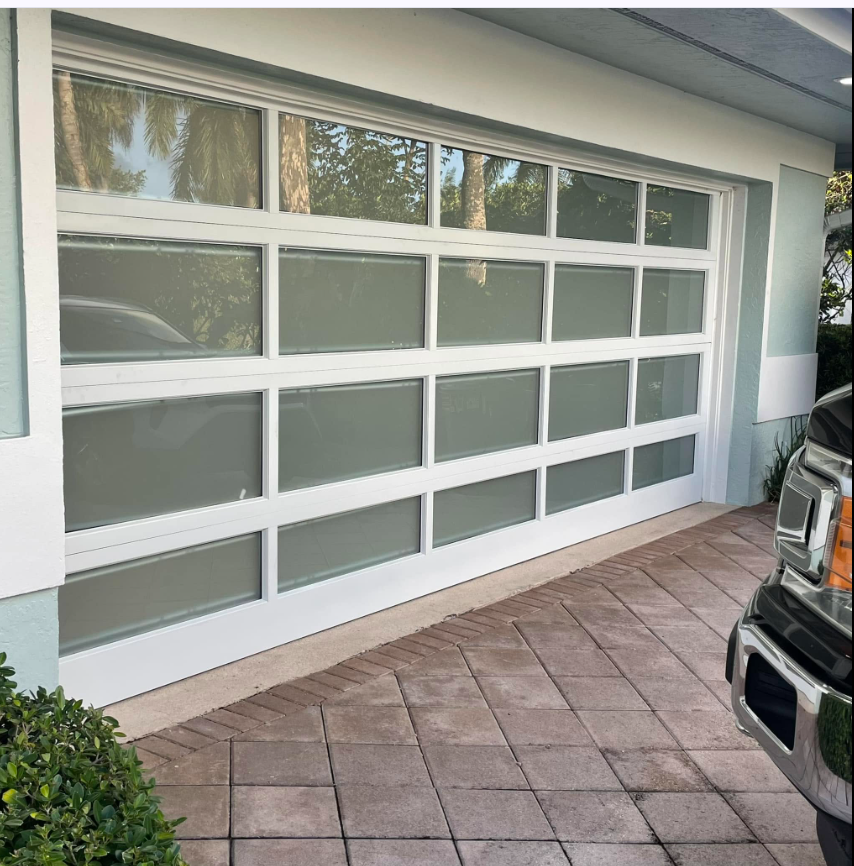 Dark wood-finish modern garage doors with vertical glass inserts installed by A Rated Garage Doors at dusk in Lakewood Ranch